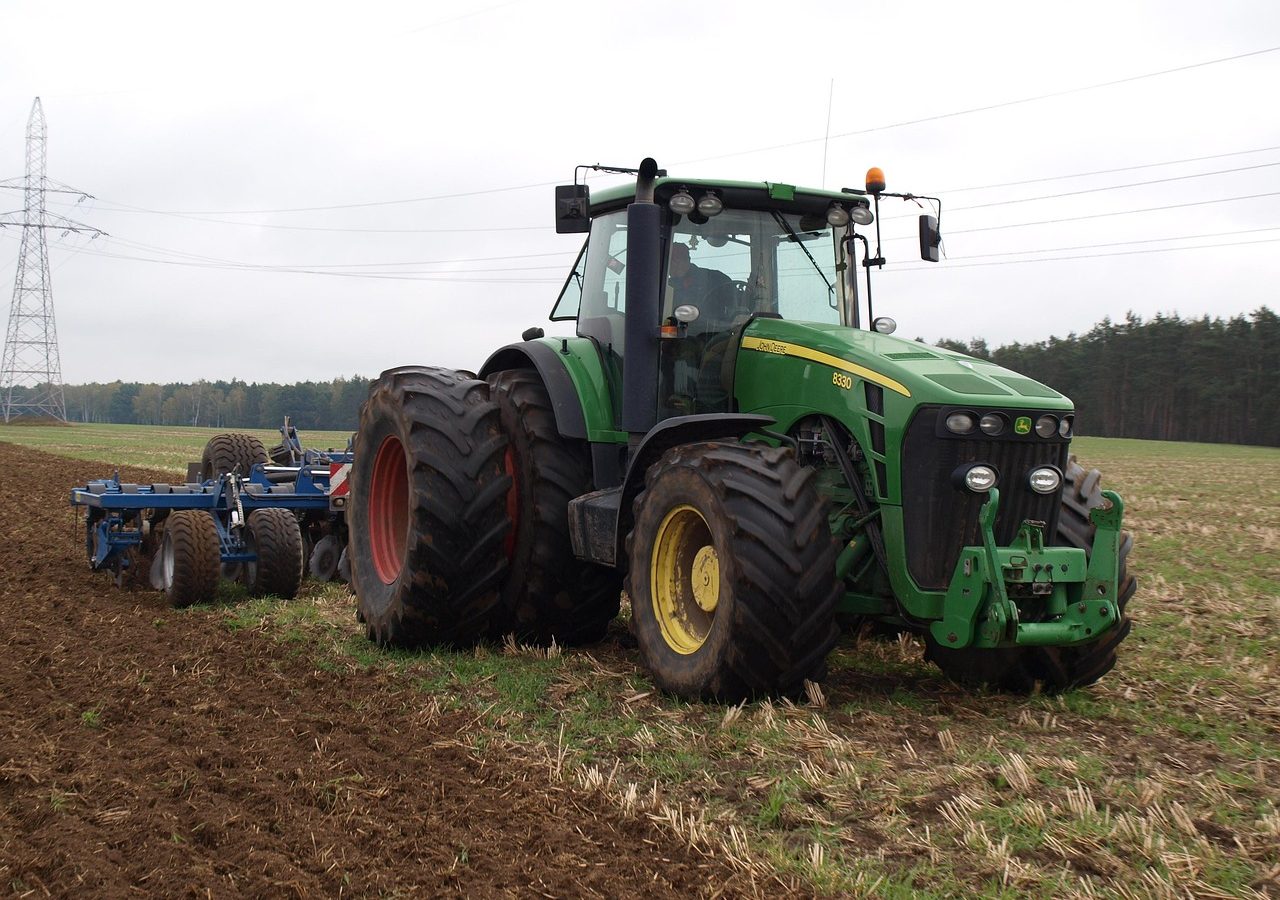 Tractor pulling a disc harrow across a field