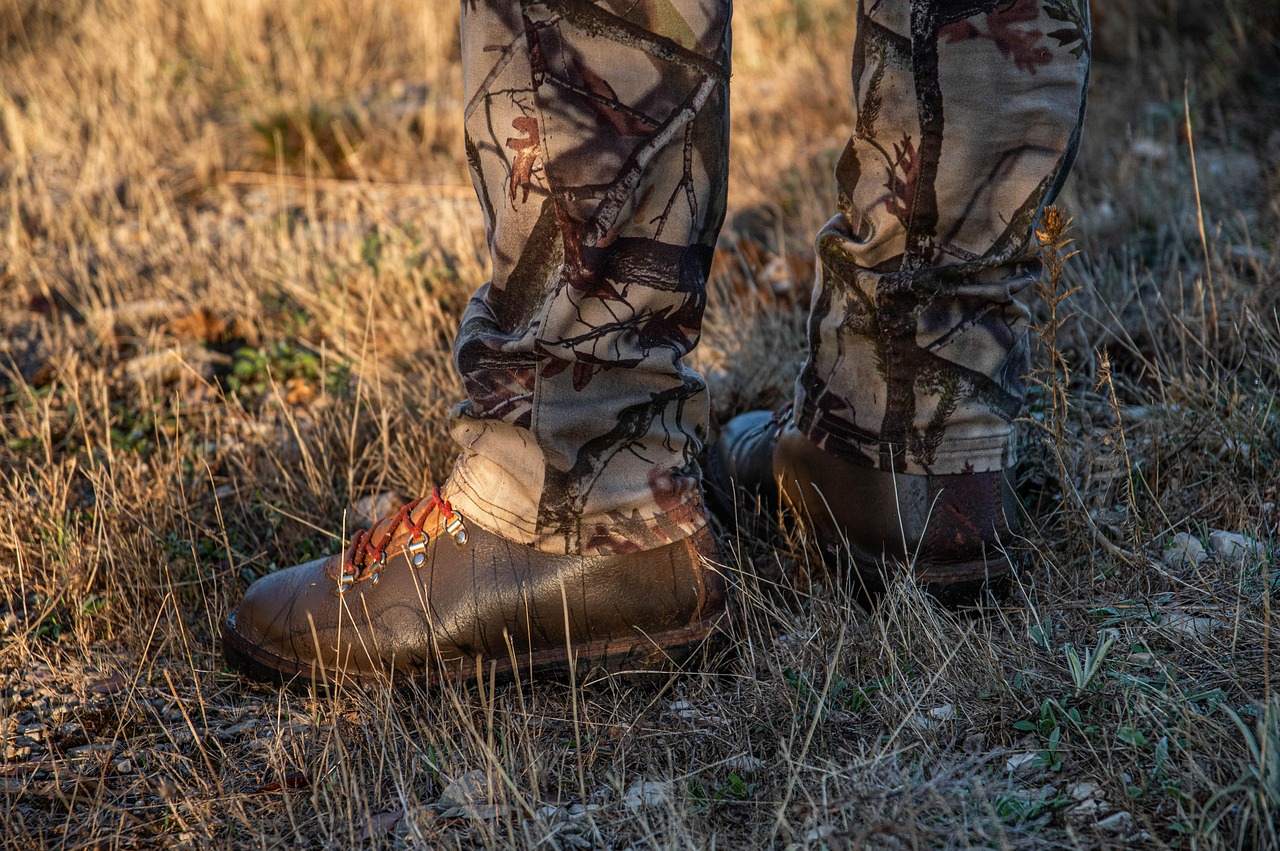 Hunter's camouflage trousers and boots in dry grass